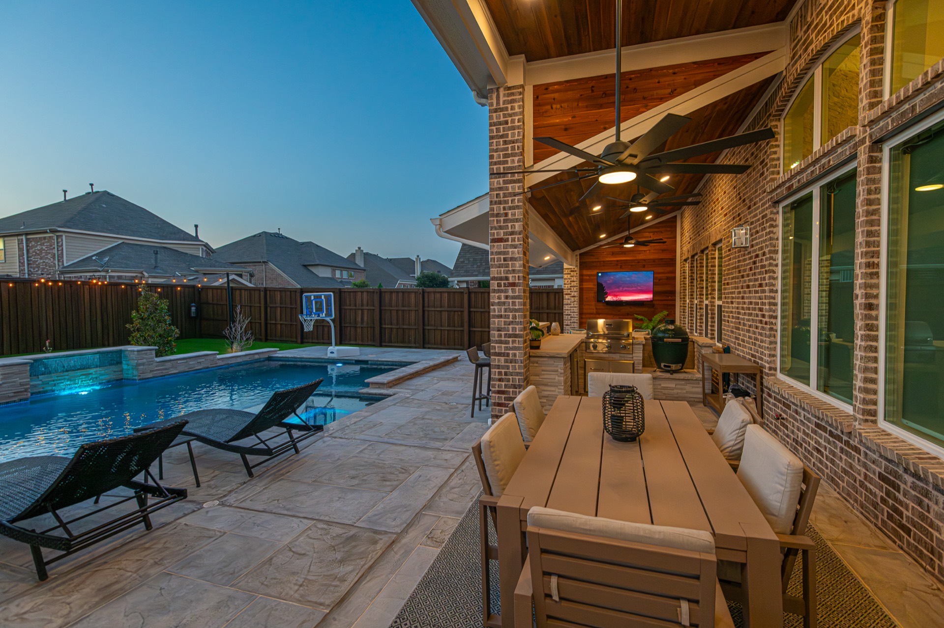 A backyard pool and covered patio at dusk in North Texas